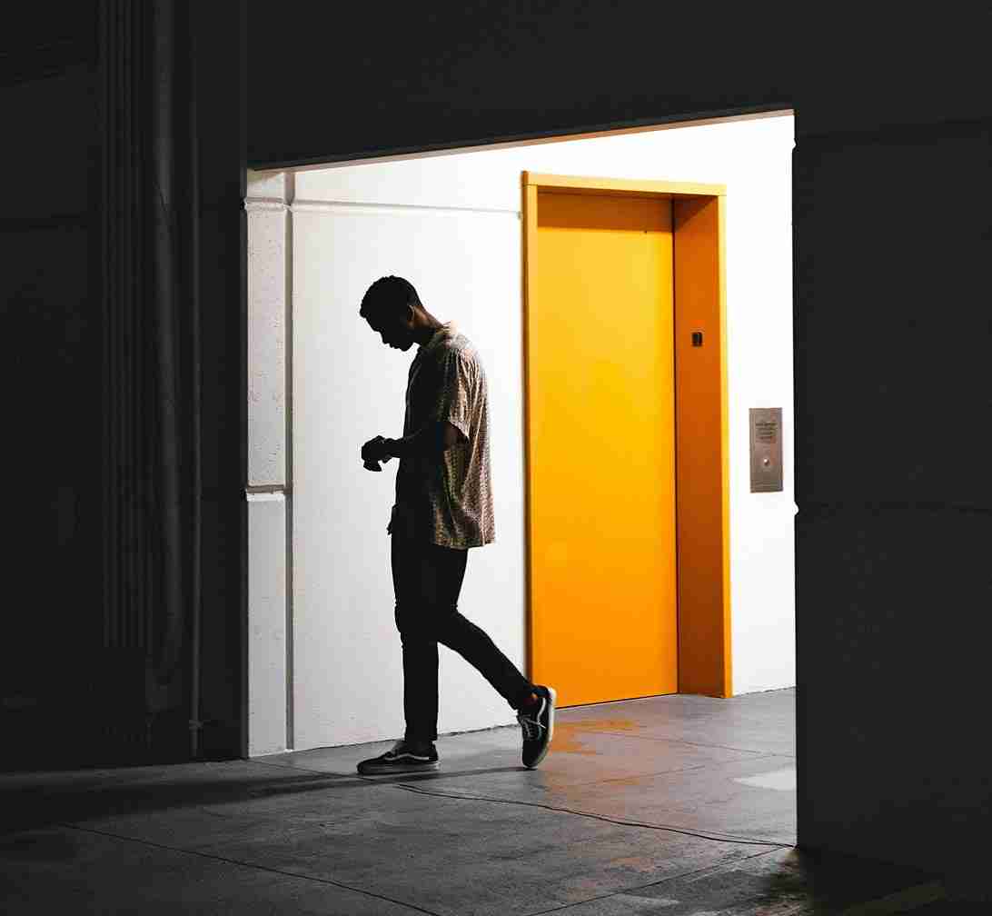 Blog – Brands Influence Hombre caminando frente a ascensor amarillo brillante
